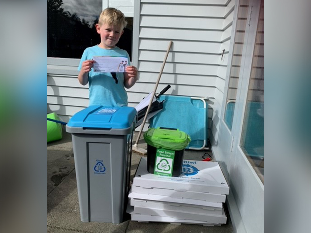 Boy with recycling bins.